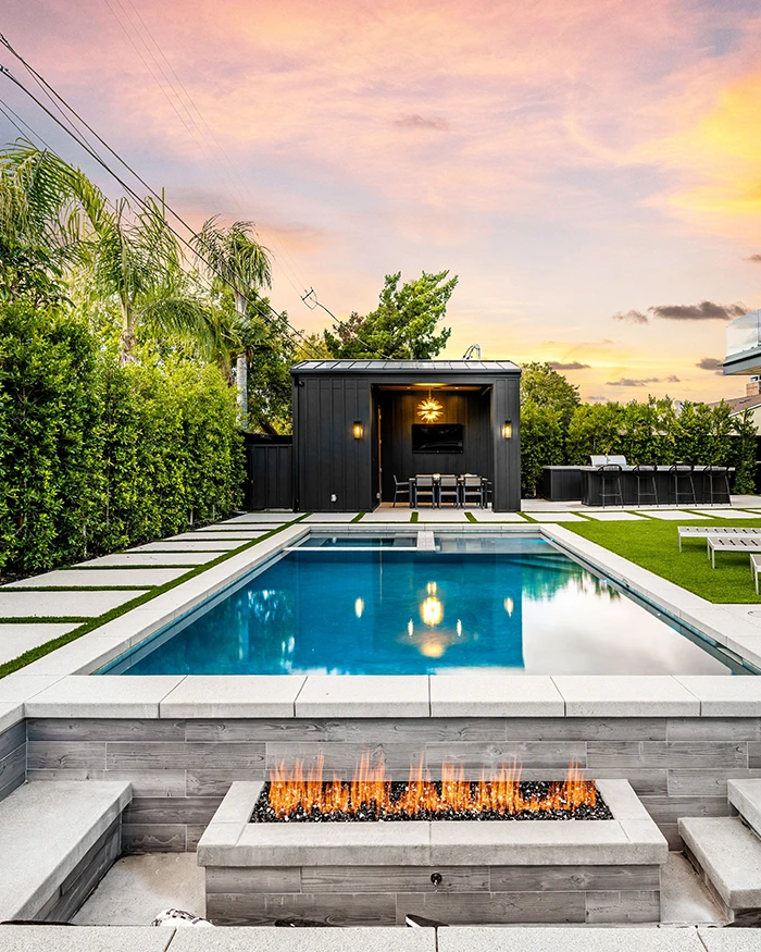 pool installed in a backyard with fireplace beside it